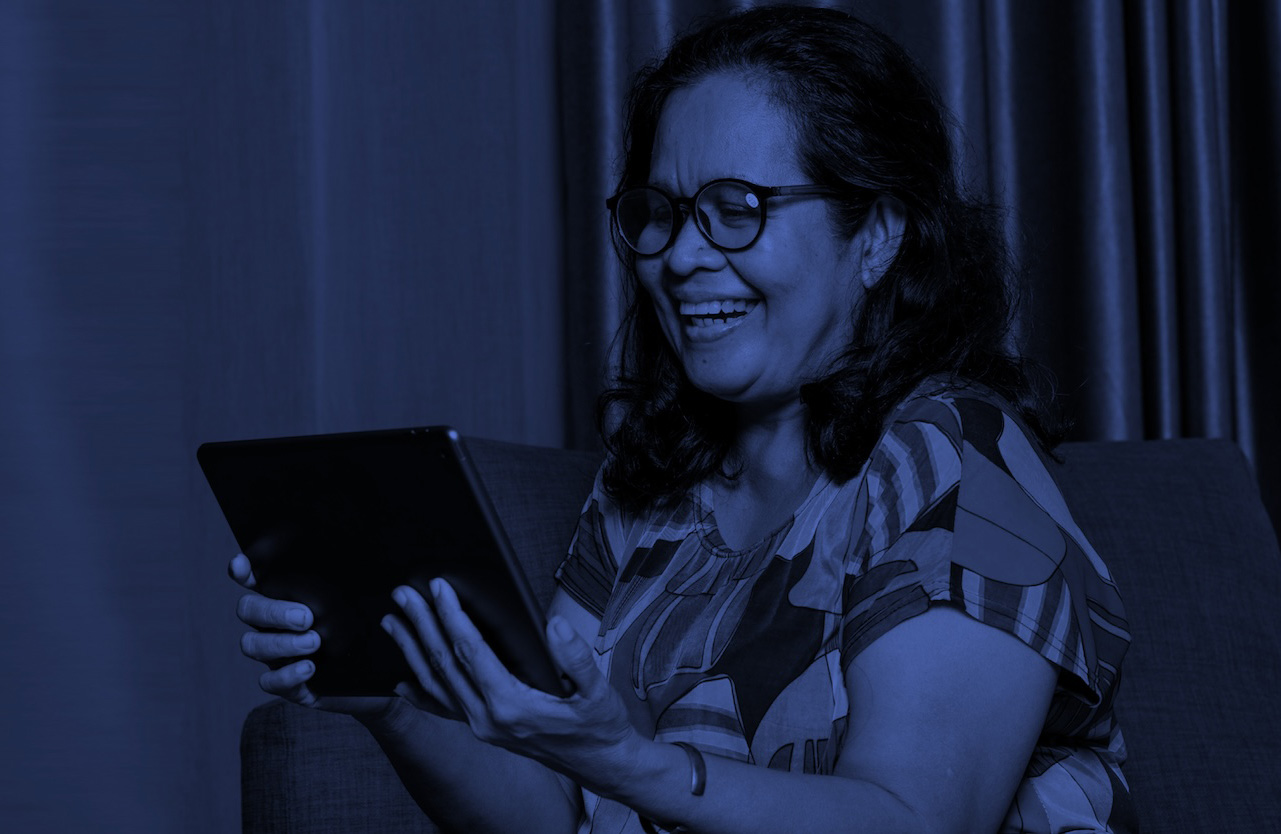 Adult woman smiling as she learns on a tablet: online education for adults